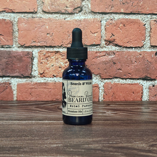 Beards & Wicks' Nobel Pursuit Premium Beard Oil - 1 oz blue glass dropper bottle with kraft paper label, handcrafted in Romeoville, IL with organic oils including jojoba, argan, and broccoli seed oil for beard nourishment and conditioning