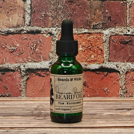 Beards & Wicks' The Woodsman Premium Beard Oil - 1 oz green glass dropper bottle with kraft paper label, handcrafted in Romeoville, IL with organic oils including jojoba, argan, and broccoli seed oil for beard nourishment and conditioning